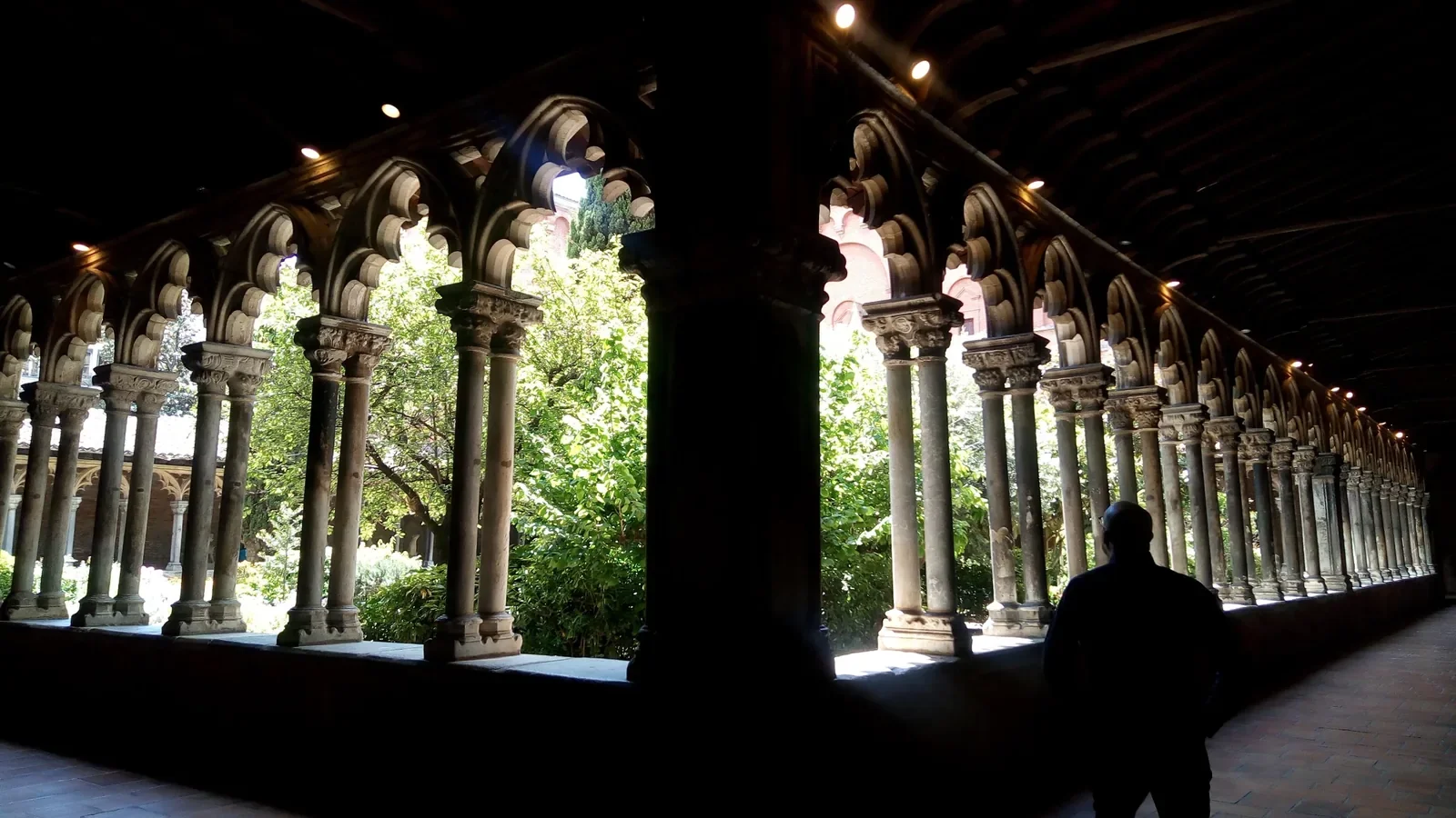 Les arcades gothiques du cloître du musée des Augustins, à Toulouse, laissent entrer la lumière du jardin.