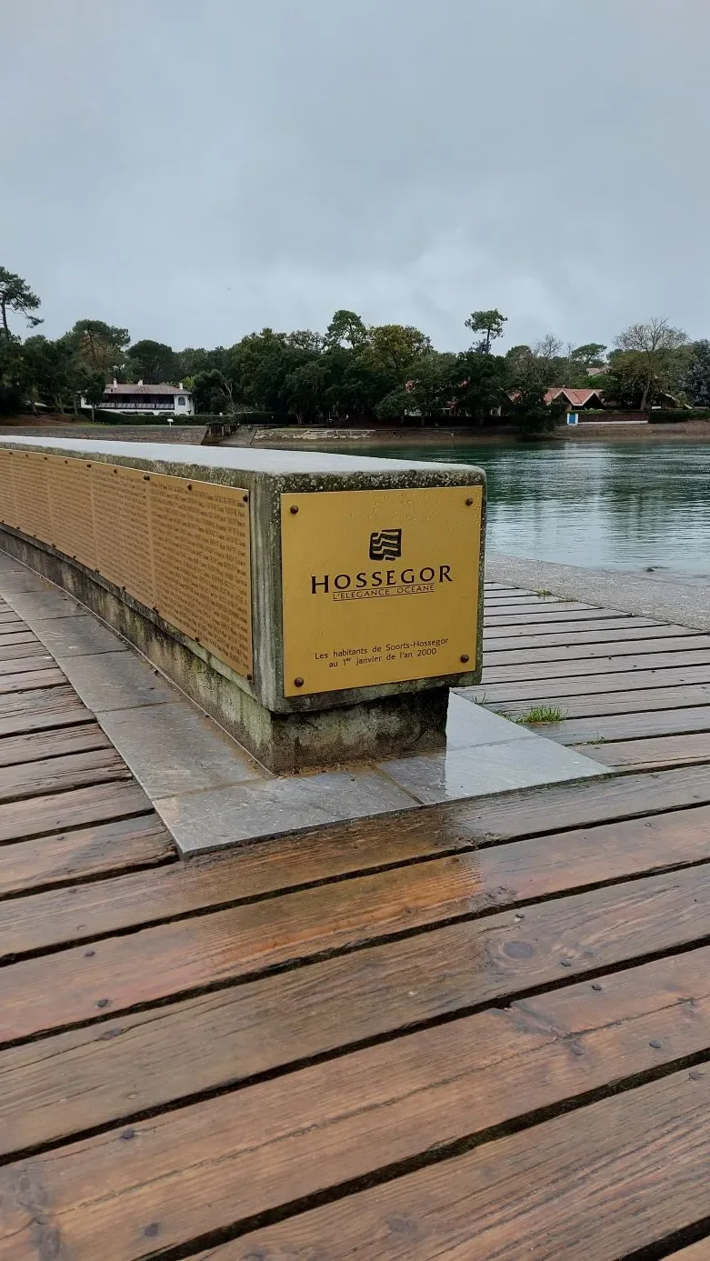 Une plaque dorée « Hossegor, l'élégance océane » rend hommage aux habitants de Soorts-Hossegor de l'an 2000, face au lac.