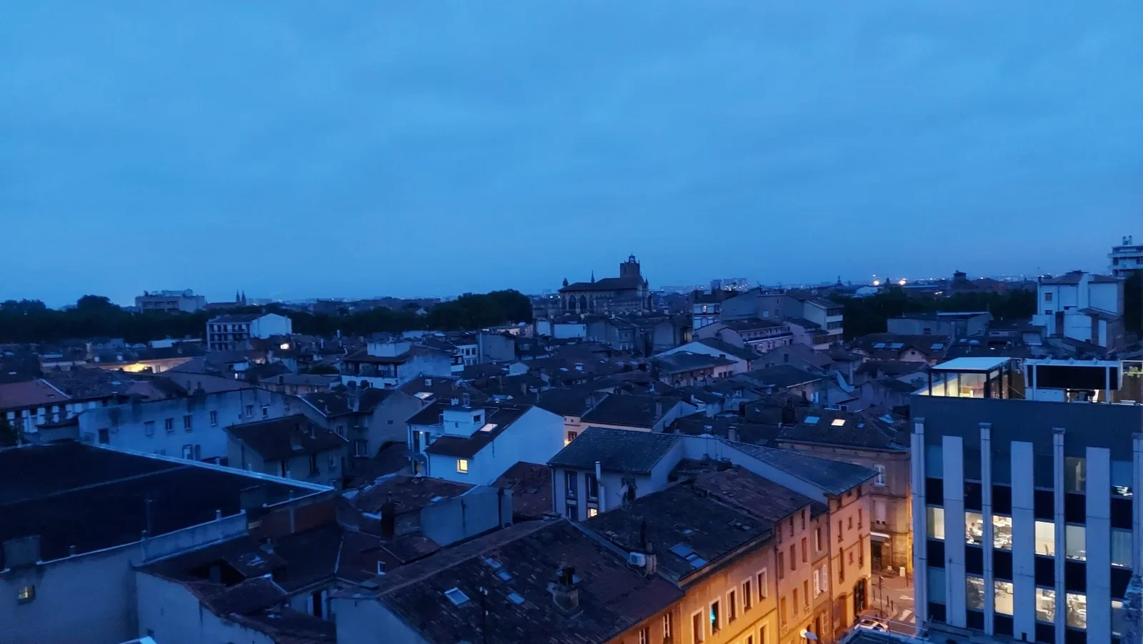 L'heure bleue : la ville s'allume, les toits deviennent d'encre.
