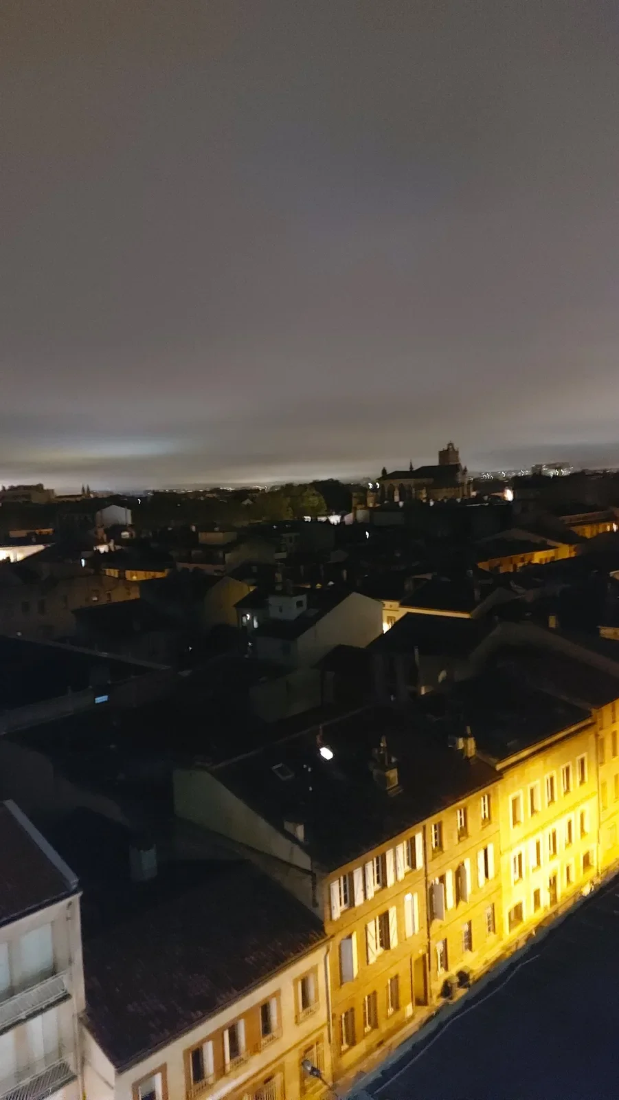 Façades éclairées en jaune et silhouette de la cathédrale Saint Etienne à Toulouse