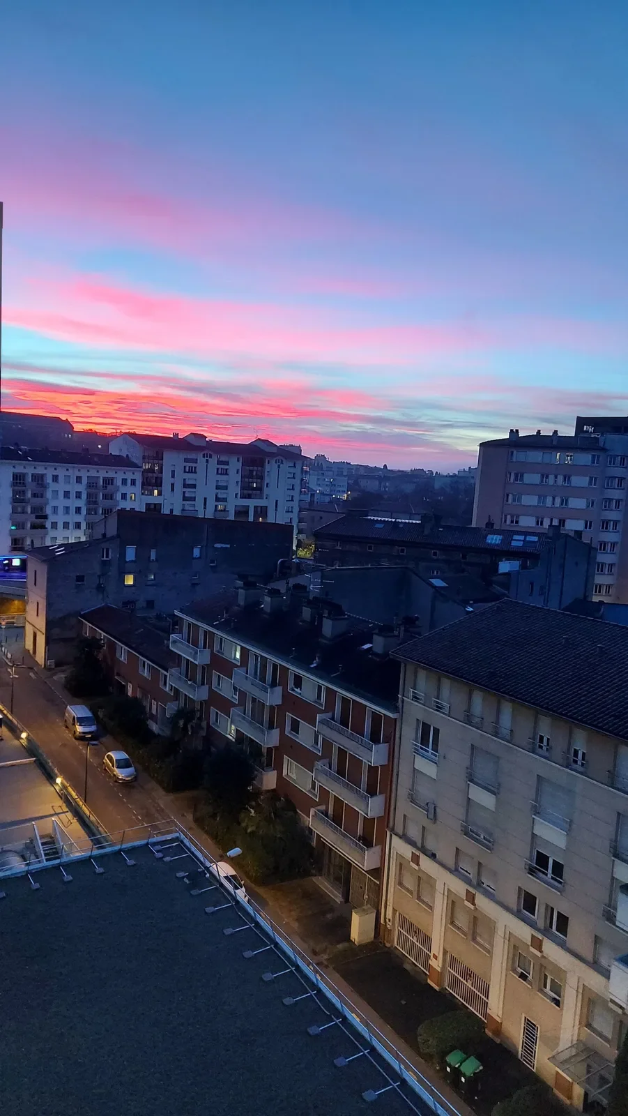 Le plus beau ciel de la série : rose, orange et bleu électrique au-dessus de la rue.