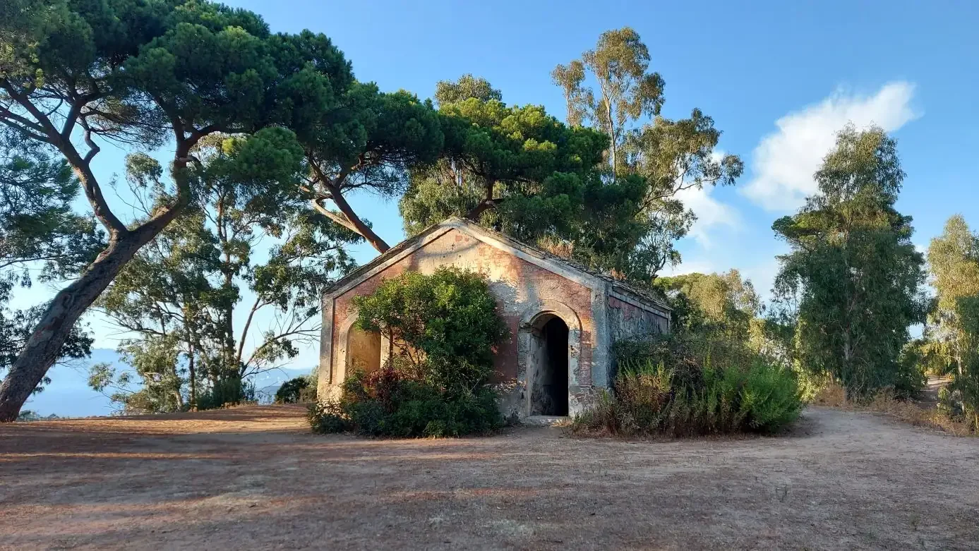 Une petite chapelle laissée à l'abandon, entourée de pins et d'eucalyptus.