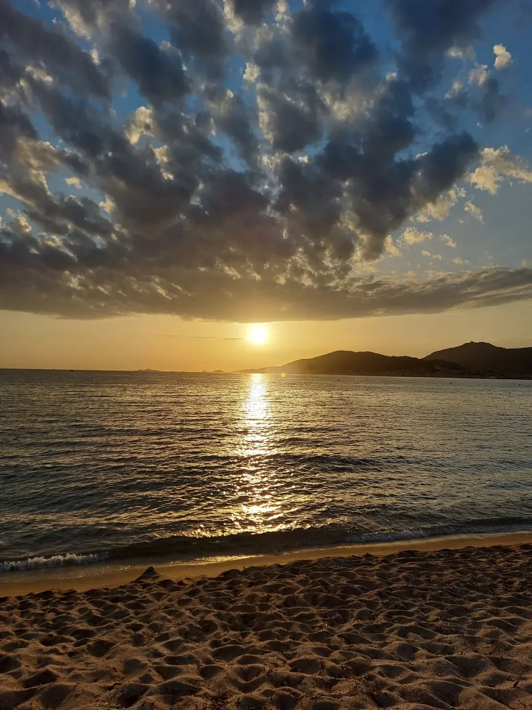 Coucher de soleil sur la mer, nuages dorés et sable, golfe d'Ajaccio
