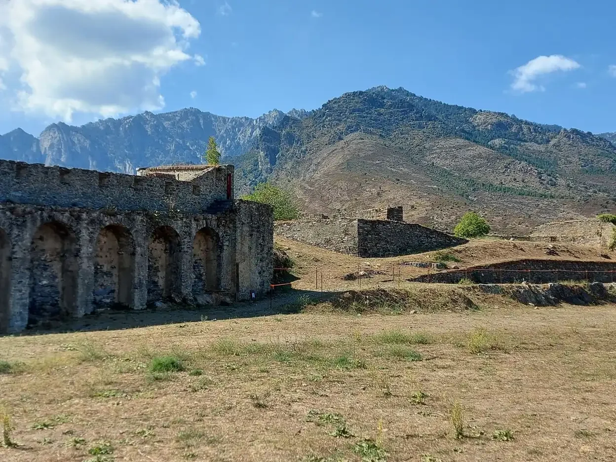 Murs de pierre fortifiés en ruine devant les montagnes de Corte